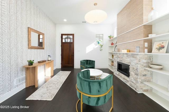 entryway with baseboards, visible vents, dark wood finished floors, recessed lighting, and a stone fireplace