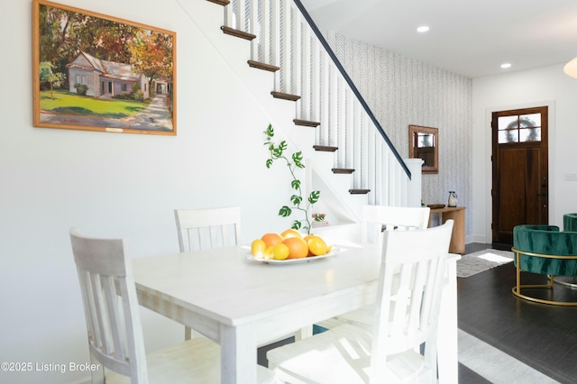 dining room with wood finished floors, recessed lighting, stairway, wallpapered walls, and baseboards