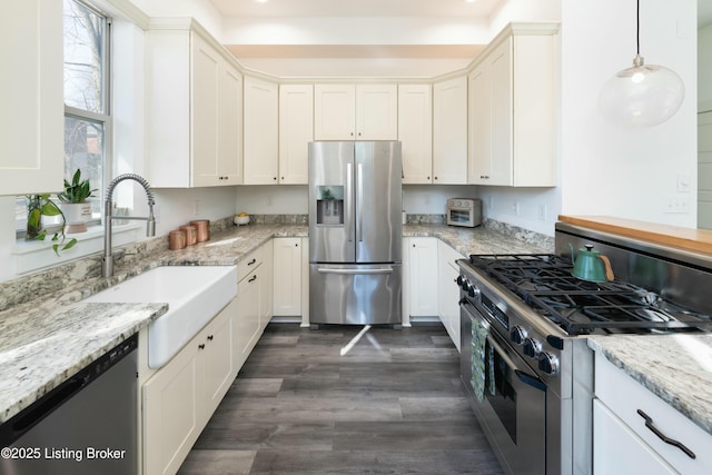 kitchen with a sink, stainless steel appliances, dark wood-style floors, and white cabinetry