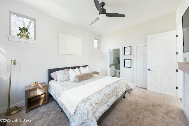 carpeted bedroom with ensuite bathroom and ceiling fan