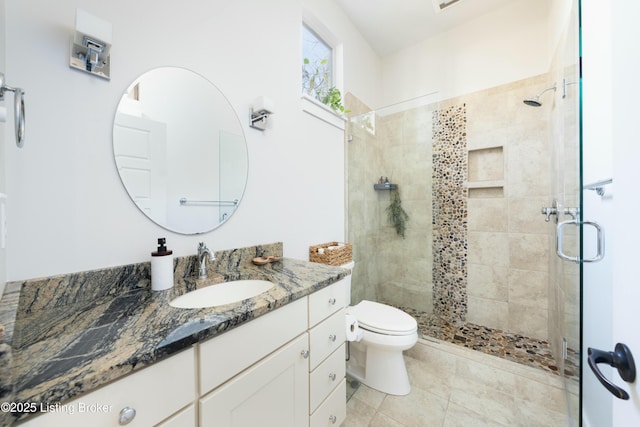 bathroom featuring tile patterned floors, a shower stall, toilet, and vanity