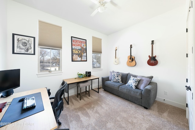 carpeted office space featuring baseboards and a ceiling fan