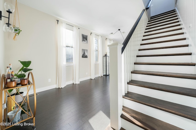 stairway featuring baseboards and hardwood / wood-style flooring