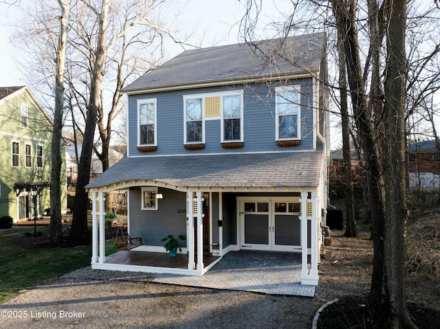 view of front of house featuring a garage, aphalt driveway, a shingled roof, and french doors