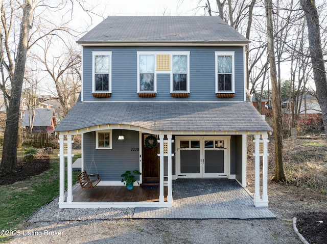 view of front of home with french doors and a shingled roof