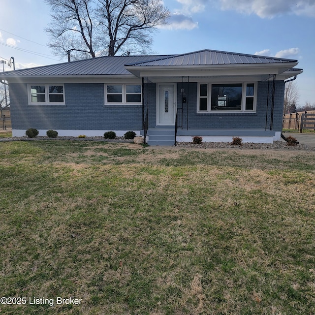 ranch-style house with brick siding, a porch, metal roof, and a front yard