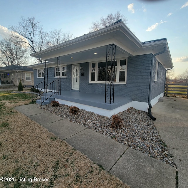 single story home with brick siding and a porch