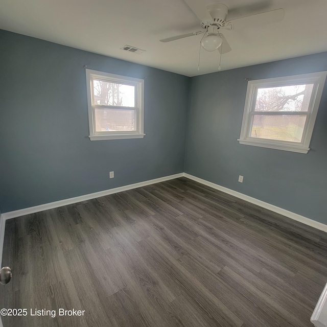 empty room with a ceiling fan, visible vents, a wealth of natural light, and baseboards