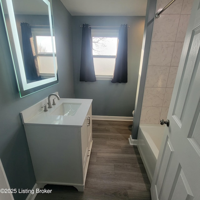 full bathroom featuring baseboards, toilet, wood finished floors, and vanity