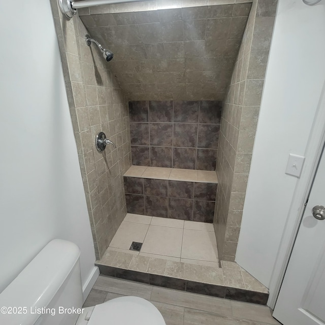 full bath featuring toilet and a tile shower