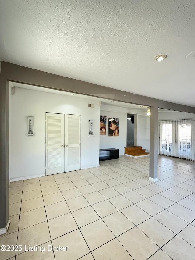 unfurnished living room featuring light tile patterned floors, visible vents, and a textured ceiling