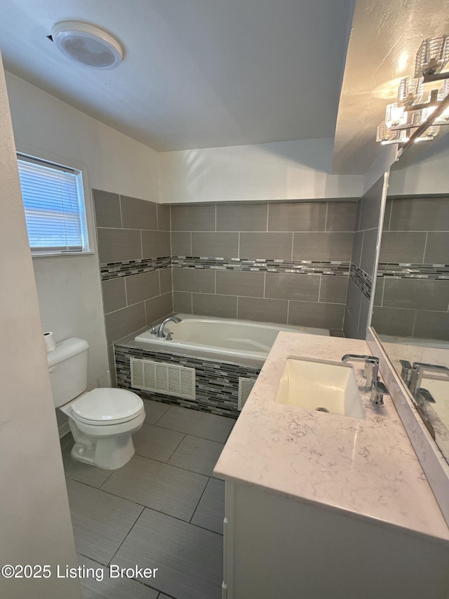 full bath with visible vents, toilet, vanity, and a garden tub