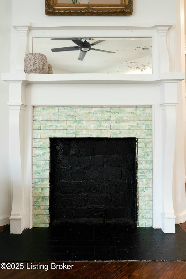 details with a fireplace, a ceiling fan, and wood finished floors