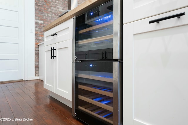 interior details featuring wine cooler, dark wood-style flooring, and white cabinets