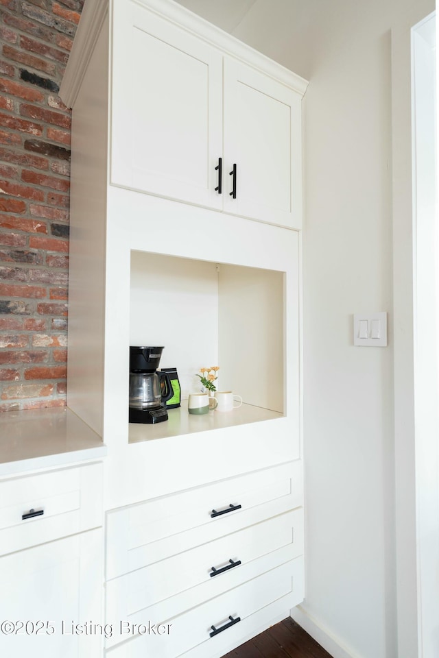 interior space featuring baseboards and brick wall