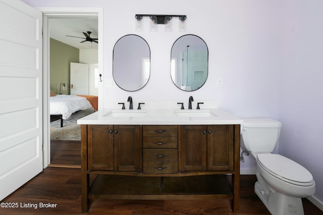 ensuite bathroom with wood finished floors, connected bathroom, toilet, and a sink