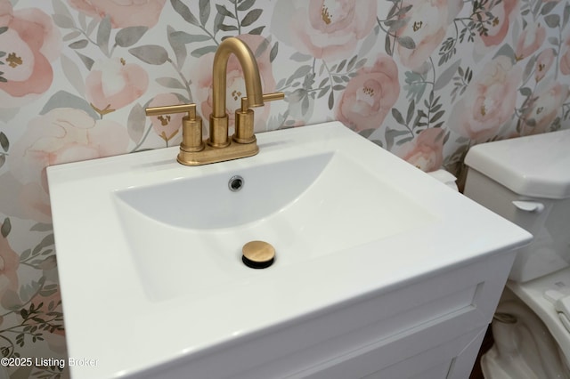 interior details with toilet, wallpapered walls, and vanity