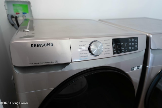 clothes washing area featuring laundry area and washer and clothes dryer