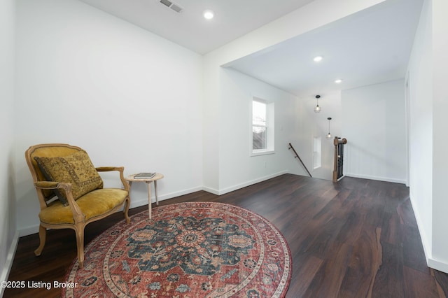 sitting room featuring an upstairs landing, visible vents, baseboards, and dark wood-style flooring