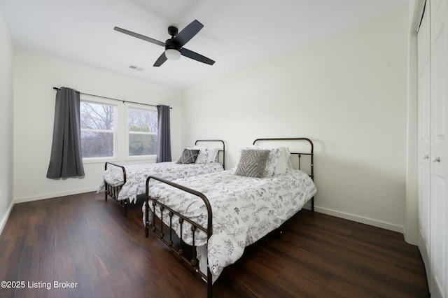 bedroom featuring wood finished floors, visible vents, a closet, and baseboards