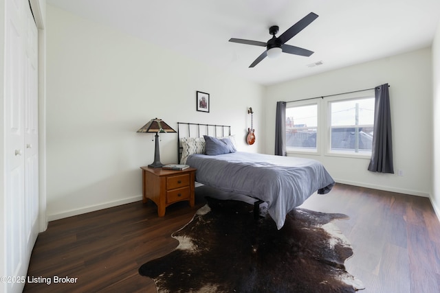 bedroom featuring visible vents, baseboards, a ceiling fan, and dark wood-style flooring