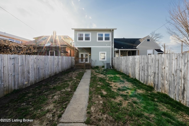 rear view of property with a fenced backyard