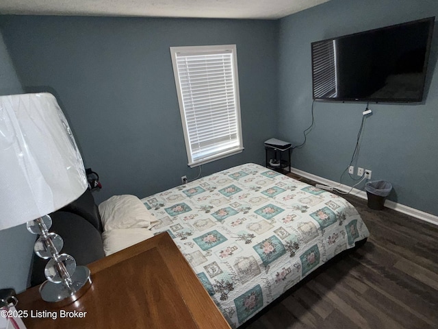 bedroom featuring baseboards and wood finished floors