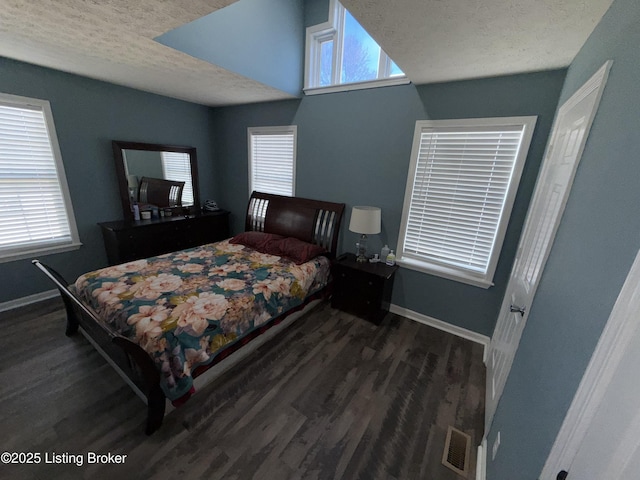 bedroom featuring visible vents, baseboards, a textured ceiling, and wood finished floors