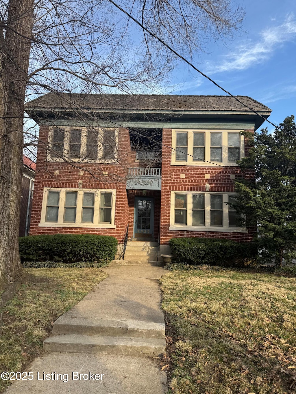 view of front of home with brick siding and a front lawn