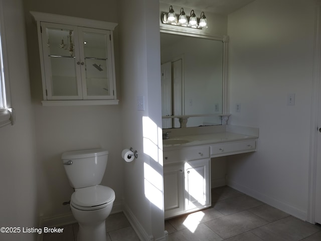 bathroom featuring tile patterned floors, toilet, vanity, and baseboards