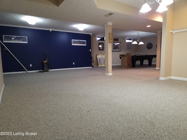 below grade area with a chandelier, a textured ceiling, crown molding, and baseboards