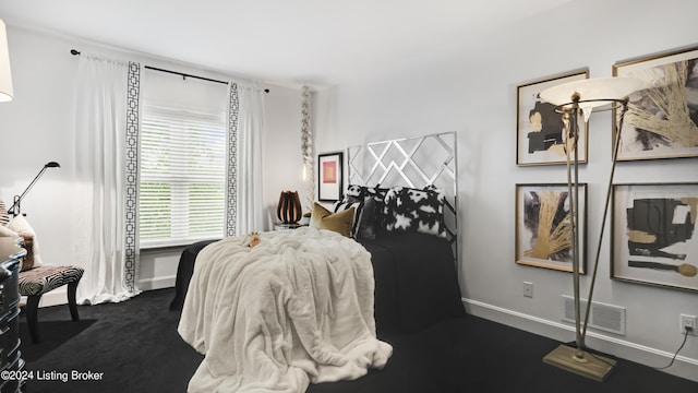 bedroom featuring visible vents, dark carpet, and baseboards