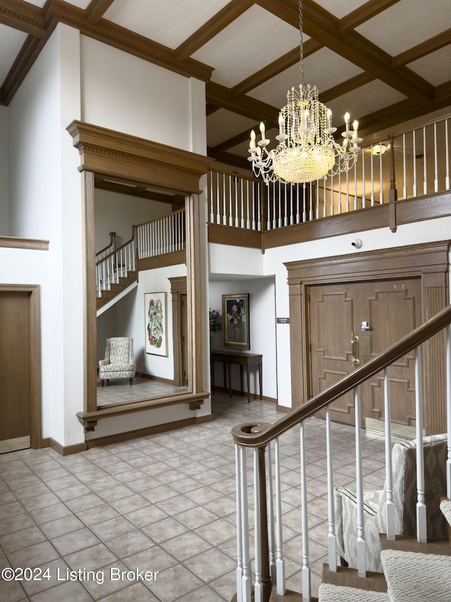 stairway featuring beam ceiling, coffered ceiling, a towering ceiling, baseboards, and a chandelier