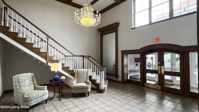 entrance foyer with stairs, french doors, an inviting chandelier, a towering ceiling, and arched walkways