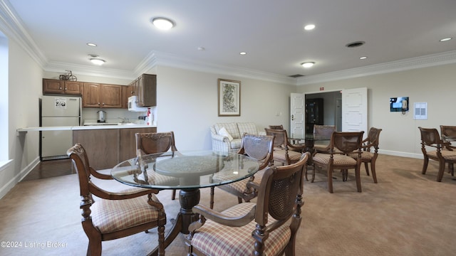 dining room with recessed lighting, light colored carpet, baseboards, and ornamental molding