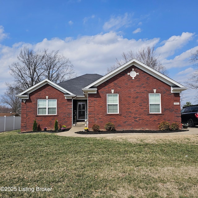 ranch-style house featuring a front yard, fence, and brick siding