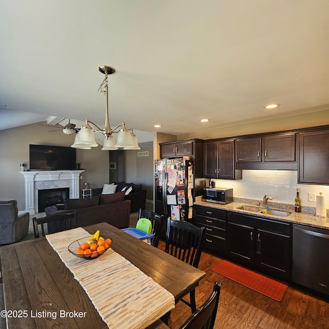 dining space featuring dark wood-type flooring, recessed lighting, visible vents, and a high end fireplace