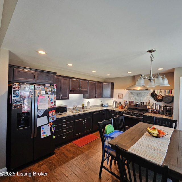 kitchen with a sink, dark wood-type flooring, dark brown cabinets, appliances with stainless steel finishes, and exhaust hood