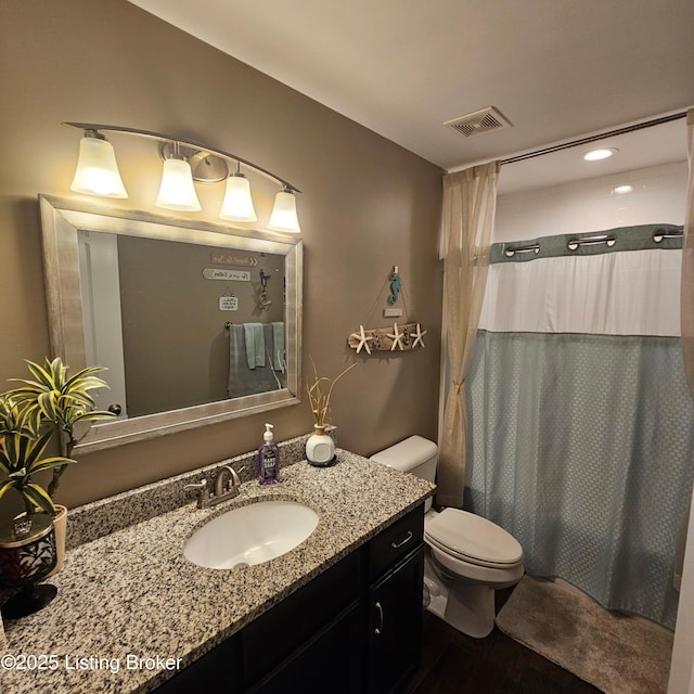 bathroom with visible vents, curtained shower, toilet, and vanity