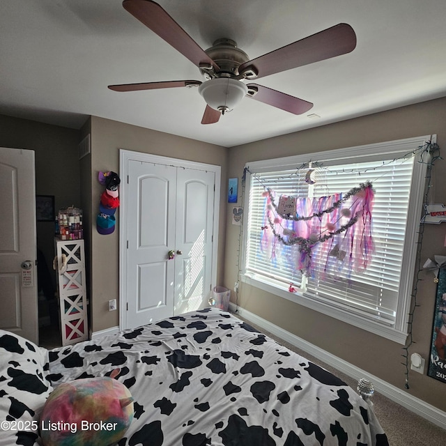 bedroom with a closet, multiple windows, baseboards, and a ceiling fan