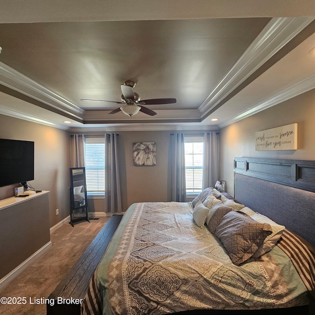 carpeted bedroom with baseboards, a tray ceiling, and ornamental molding