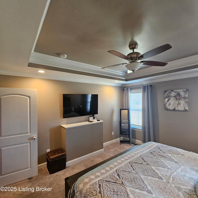 bedroom with a raised ceiling, ornamental molding, a ceiling fan, carpet floors, and baseboards