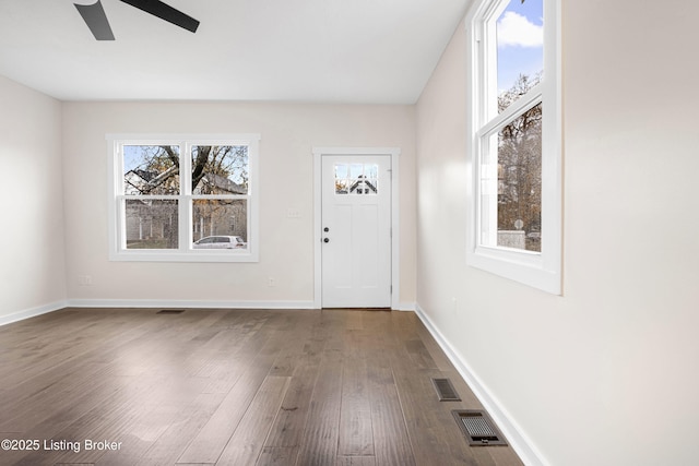 foyer entrance featuring visible vents, baseboards, dark wood-type flooring, and ceiling fan