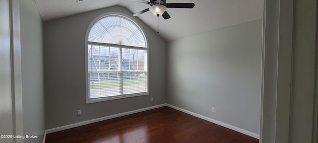 spare room featuring dark wood-style floors, baseboards, lofted ceiling, and ceiling fan