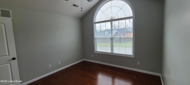 unfurnished room with baseboards, visible vents, dark wood finished floors, ceiling fan, and vaulted ceiling