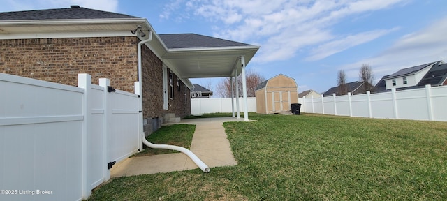 view of yard featuring an outdoor structure, a fenced backyard, and a shed