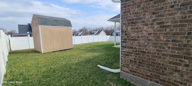 view of yard featuring an outbuilding, a storage unit, and a fenced backyard