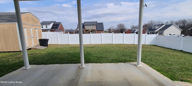 view of yard featuring a patio, a fenced backyard, a residential view, a storage shed, and an outdoor structure