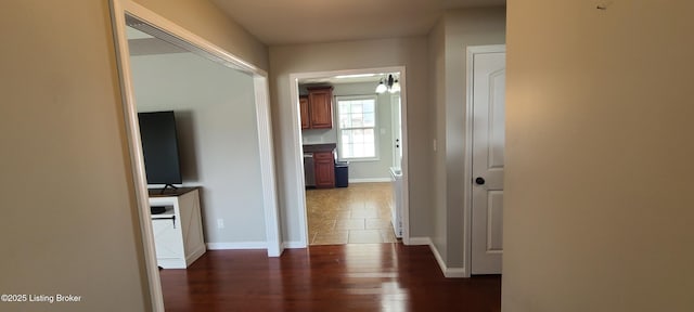 hall with dark wood-style floors and baseboards