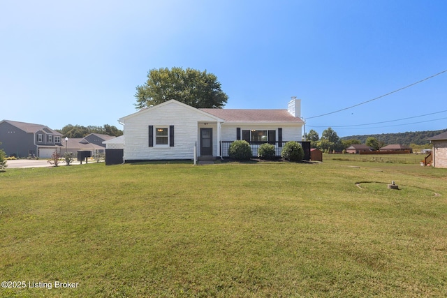 view of front of house featuring a chimney and a front lawn